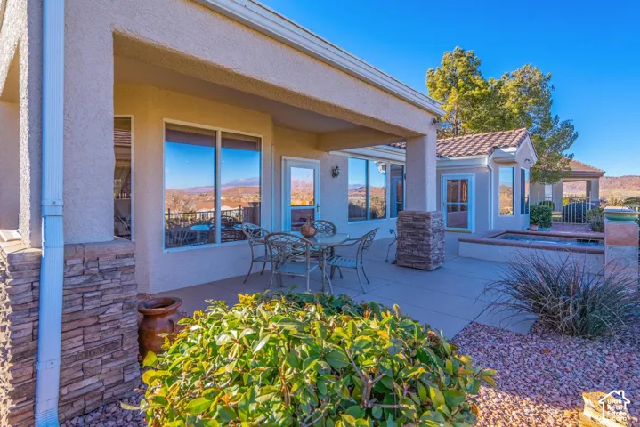 Covered patio with a stucco exterior finish and stacked stone accents