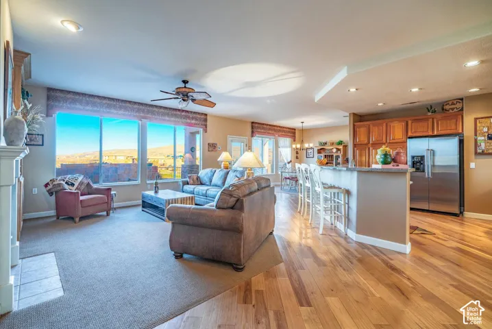 Open-concept living area with large windows, recessed lighting, and a ceiling fan