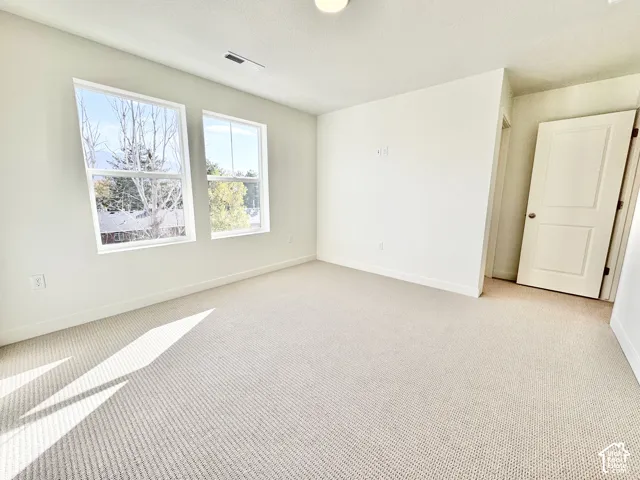 White walls with light-colored carpet, featuring two double-hung windows