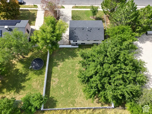 Expansive grassy yard area with perimeter fencing, mature trees.