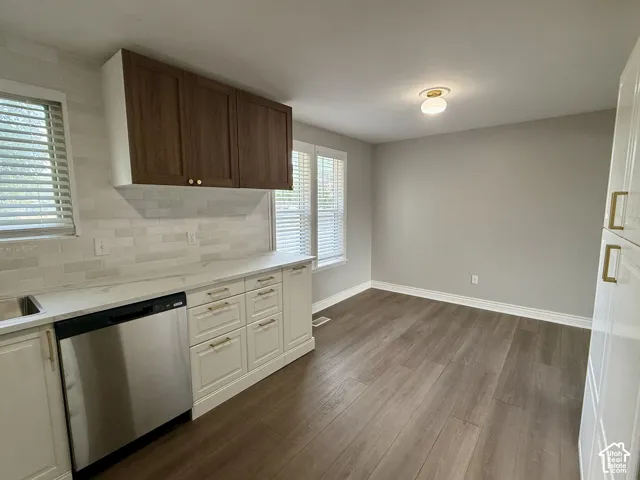Wood-finish flooring, recessed lighting, base cabinetry with gold-tone hardware, white countertop, and tiled backsplash