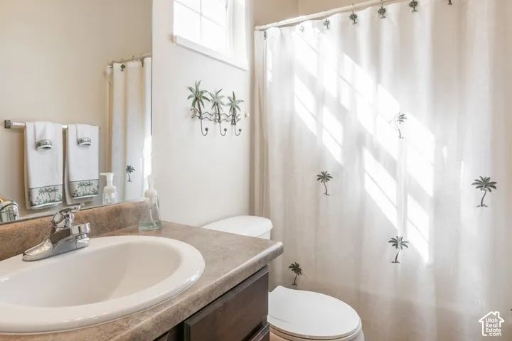 Vanity with integrated sink, chrome faucet, and expansive wall mirror