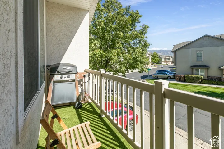Outdoor balcony with artificial turf flooring and white railing