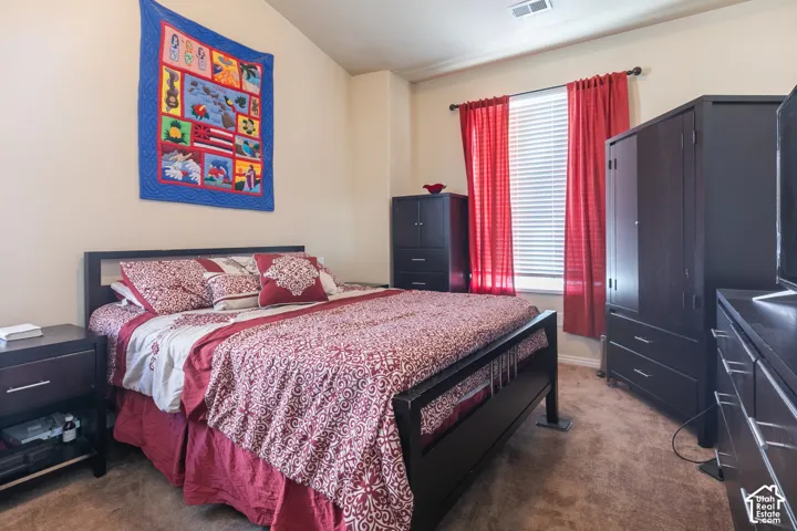 Sloped ceiling, neutral wall tones, window with blinds, and carpeted flooring
