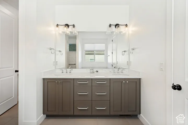 Dual vanity with a white countertop and rectangular undermount sinks, flanked by two wall-mounted light fixtures