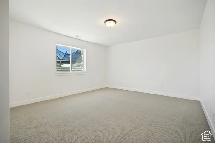 Carpeted flooring, white walls, and a window with white trim