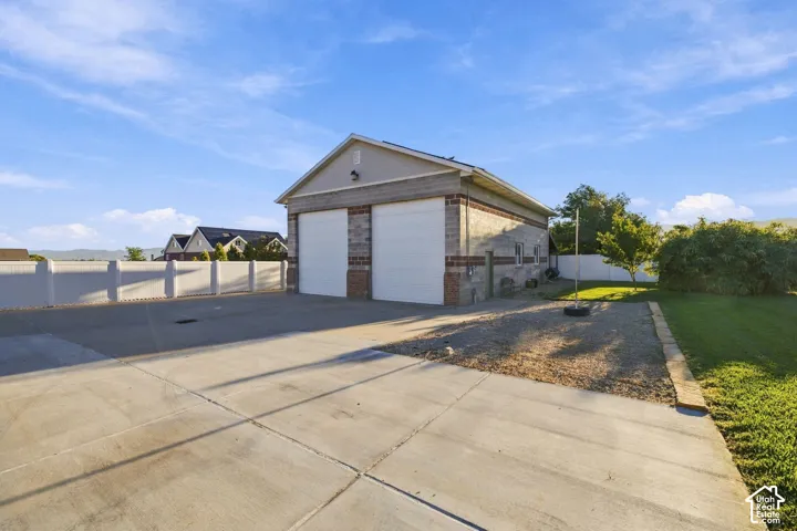 Detached garage with dual overhead doors, brick and block exterior, and a concrete driveway