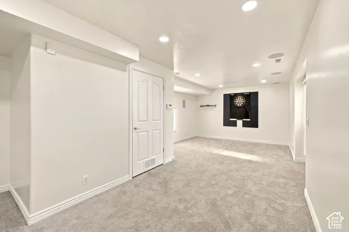 Recessed lighting, textured carpeting, white trim, paneled interior door, and built-in wall feature