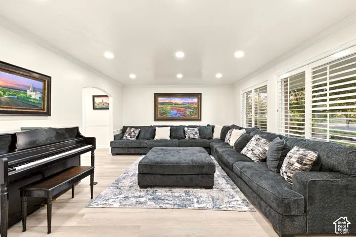 Recessed lighting, crown molding, arched entry, wood-finish flooring, and white plantation shutters