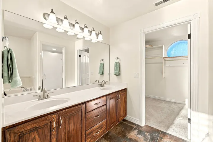 Dual vanity with integrated sinks, brushed nickel fixtures, and a large mirror