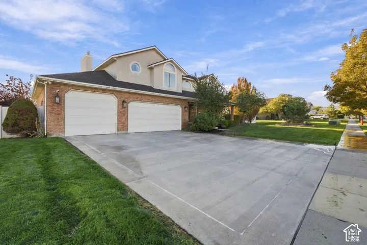 Brick and stucco exterior with multiple garage doors, a curved dormer window, and a circular window detail