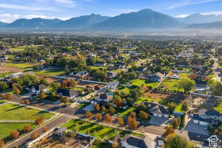 Residential neighborhood with established streets and mature trees, set against a mountain backdrop