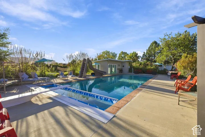 Rectangular swimming pool with integrated spa and surrounding concrete patio