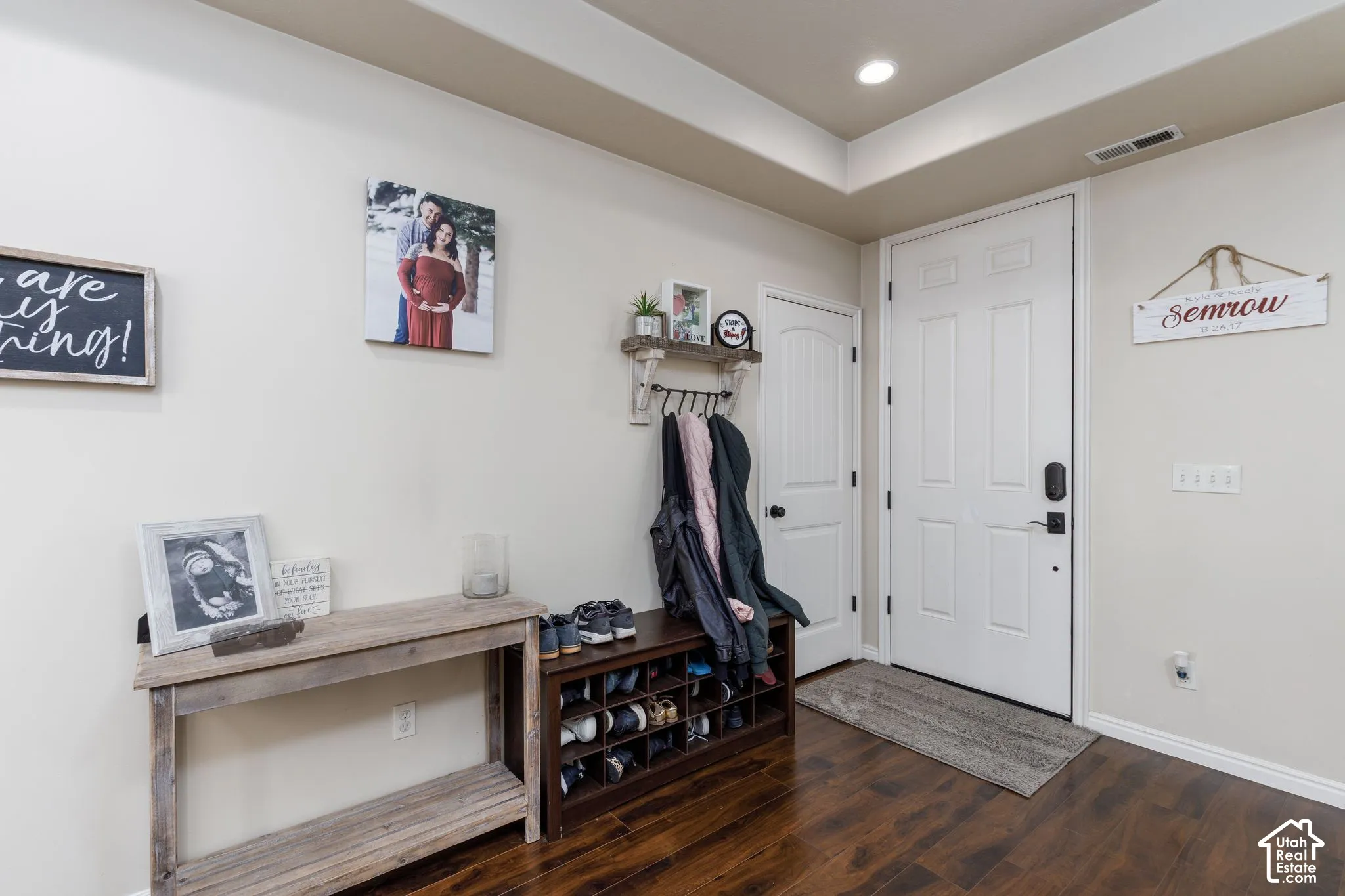 Hardwood-finish flooring, recessed lighting, tray ceiling, and a paneled entry door