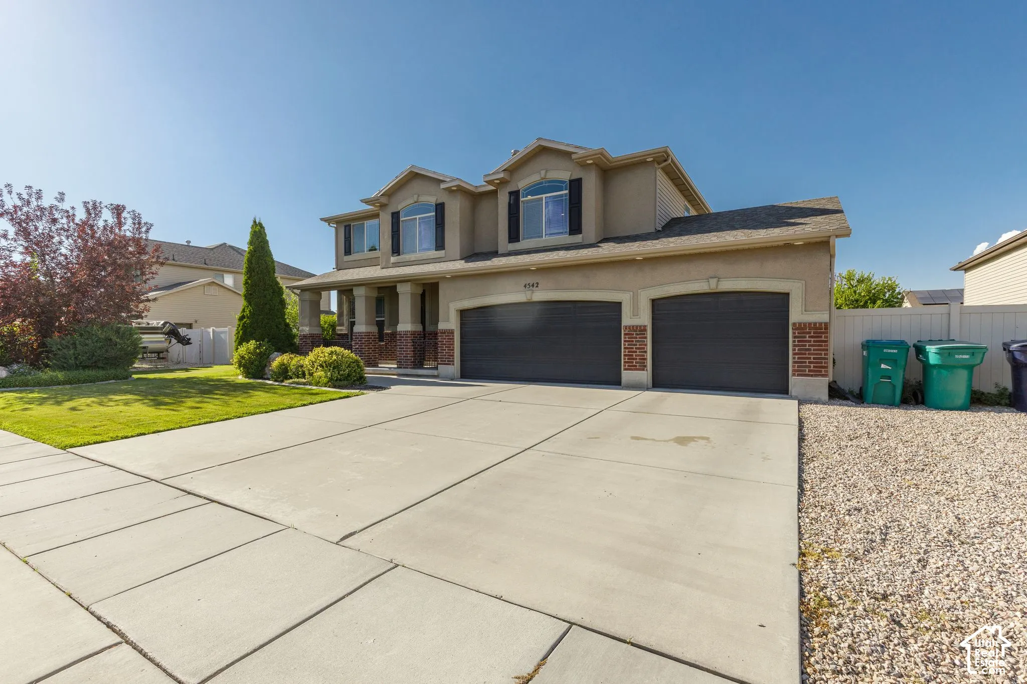 Two-story residence featuring a two-car garage, concrete driveway, and a covered front entry