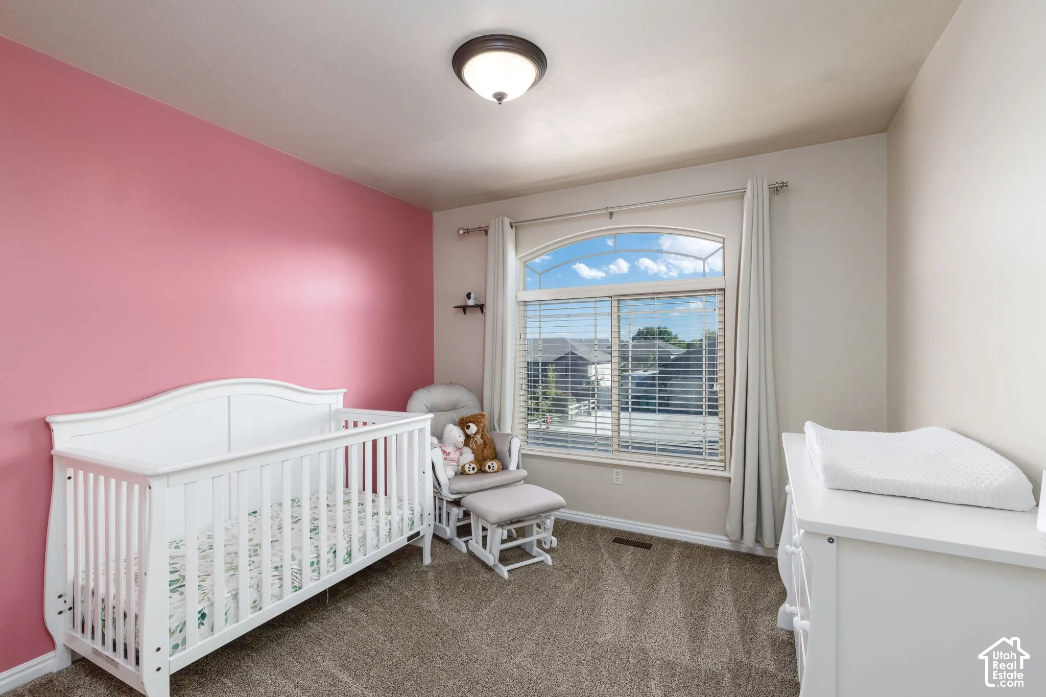 Arched window with blinds, recessed ceiling light fixture, wall-to-wall carpeting, and painted walls