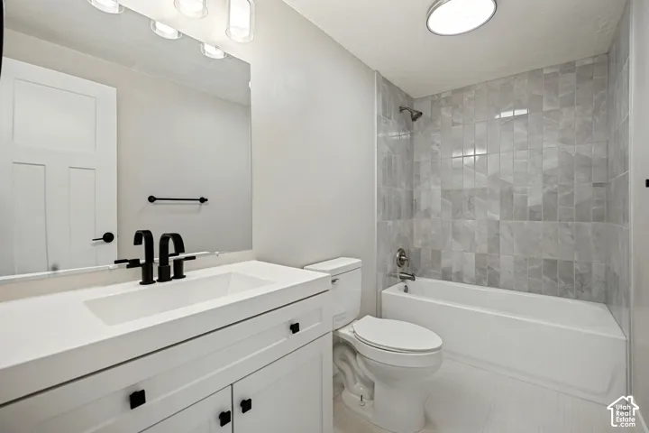 White vanity with integrated sink, black fixtures, and a large mirror