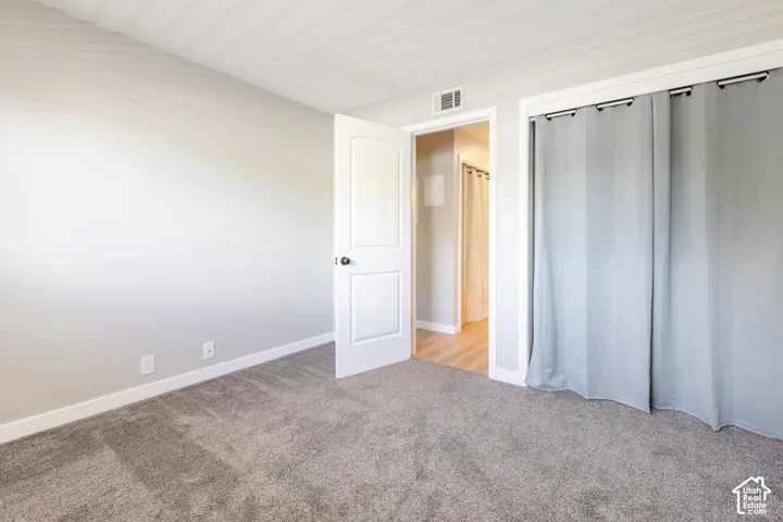 Plush gray carpeting throughout, featuring light gray wall paint and white trim