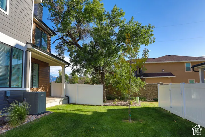 Expansive lawn area, privacy fencing, covered patio, and mature trees