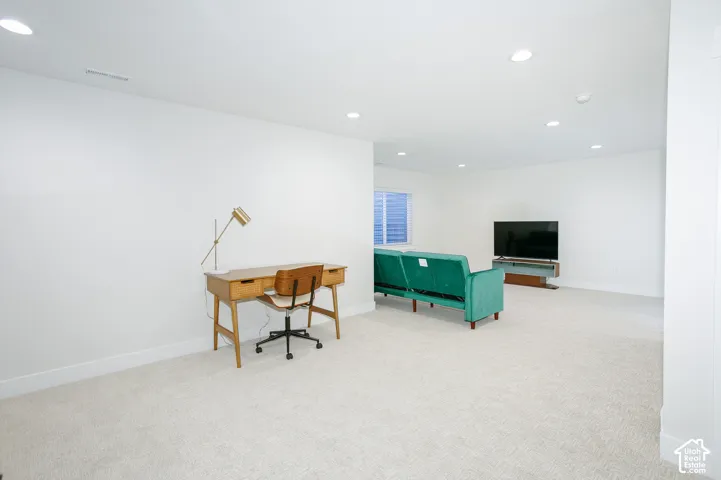 Recessed ceiling lighting, white walls, and light-colored carpeting