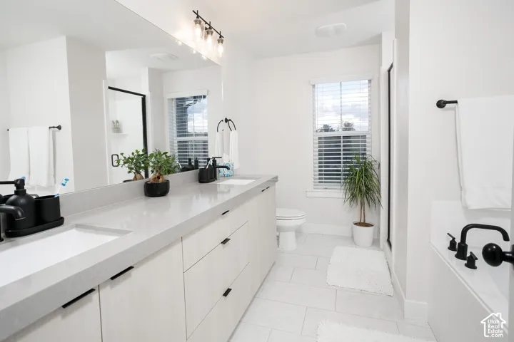 Dual sink vanity with light-toned countertop and wood-finish cabinetry, featuring a large wall-mounted mirror