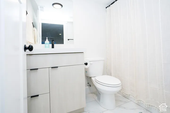 Modern vanity with a light wood-finish, featuring a white countertop and rectangular sink