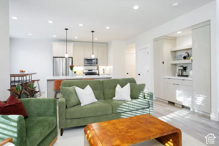 Open-concept living space featuring wood-finish flooring, recessed lighting, and a built-in beverage bar