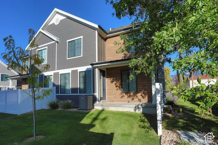 Two-story residence featuring gray siding and wood-finish accents