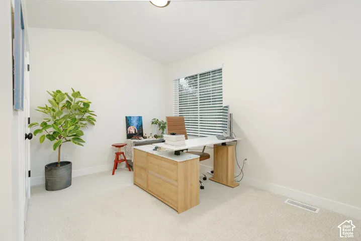 Vaulted ceiling, plush carpeting, window with blinds, light wall color, and flush-mount ceiling light
