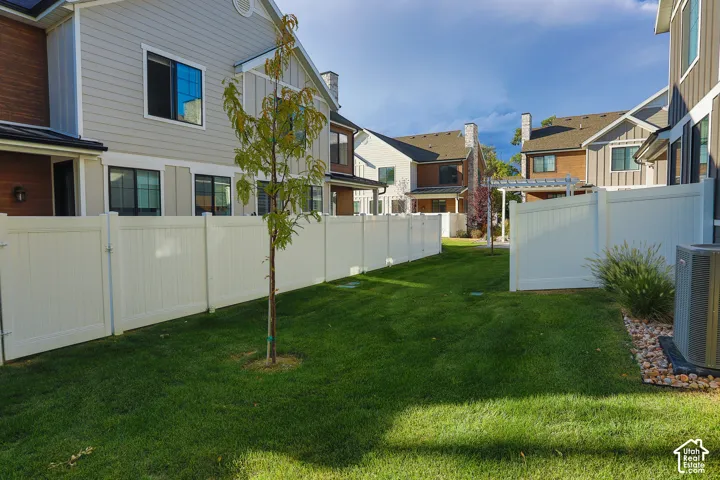 Expansive backyard featuring a manicured lawn, full privacy fencing, and a dedicated patio space