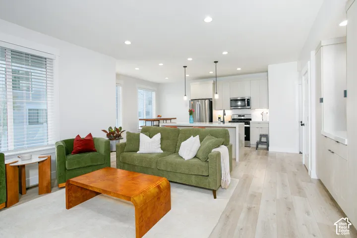 Open concept living space featuring recessed lighting, wood-finish flooring, and white walls