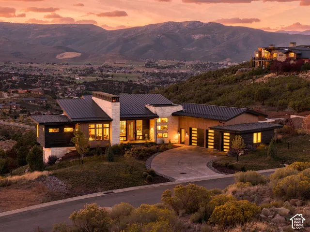 Contemporary architecture with stone and wood-look siding, featuring a metal roof