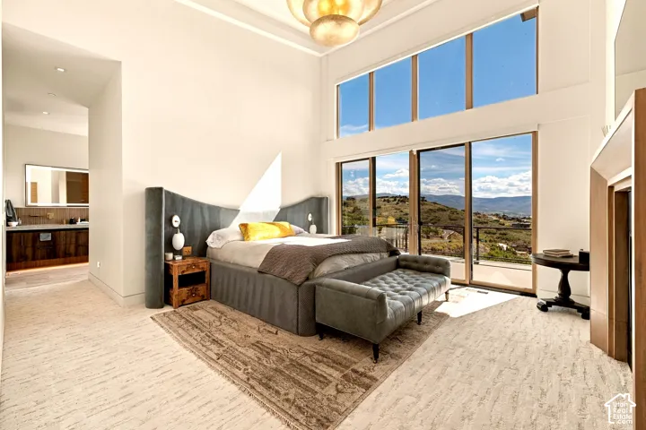 High ceilings with upper transom windows, sliding glass door balcony access, light-toned flooring, and an open concept layout