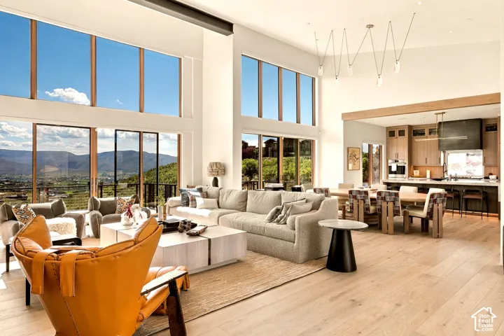 Soaring ceilings with extensive window arrays, light wood-finish flooring, and an open-concept living space