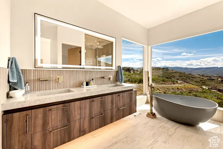 Dual vanity with wood-finish cabinetry, light-toned countertop, and integrated sinks