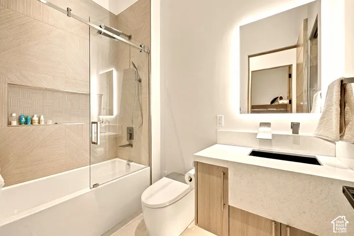 Integrated bathtub with sliding glass shower door, patterned tile surround, and recessed shelving