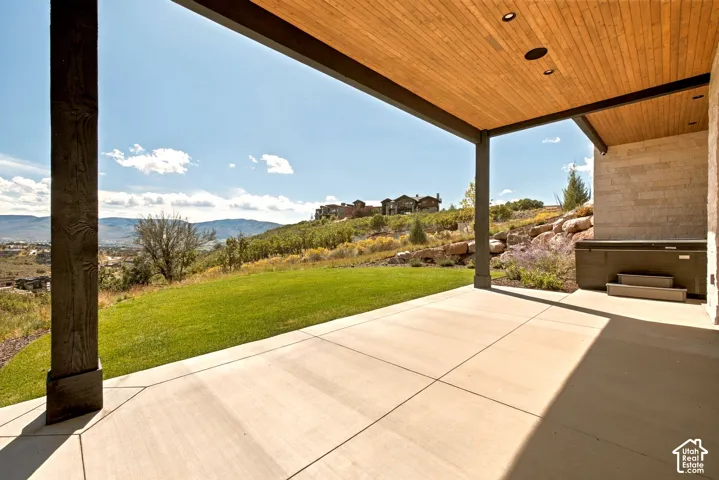 Expansive concrete patio with a wood-finish ceiling and recessed lighting