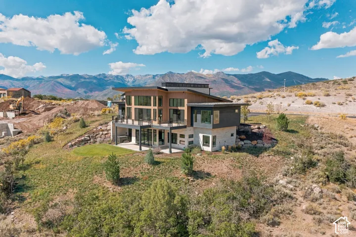 Multi-level contemporary residence featuring extensive glazing, multiple balconies with metal railings, and a flat roofline