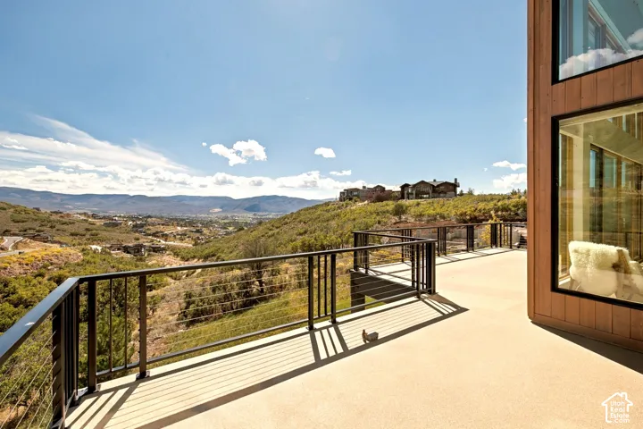 Expansive outdoor deck with cable railings and panoramic distant mountain scenery