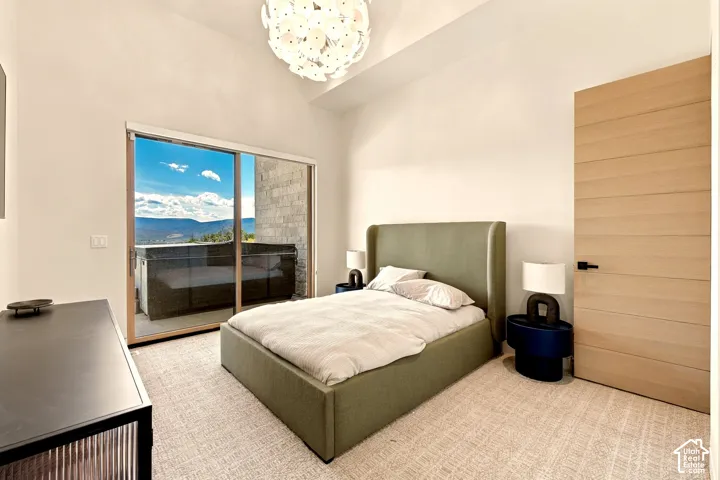 Vaulted ceilings, a contemporary light fixture, and a light wood-finish door with matte black hardware