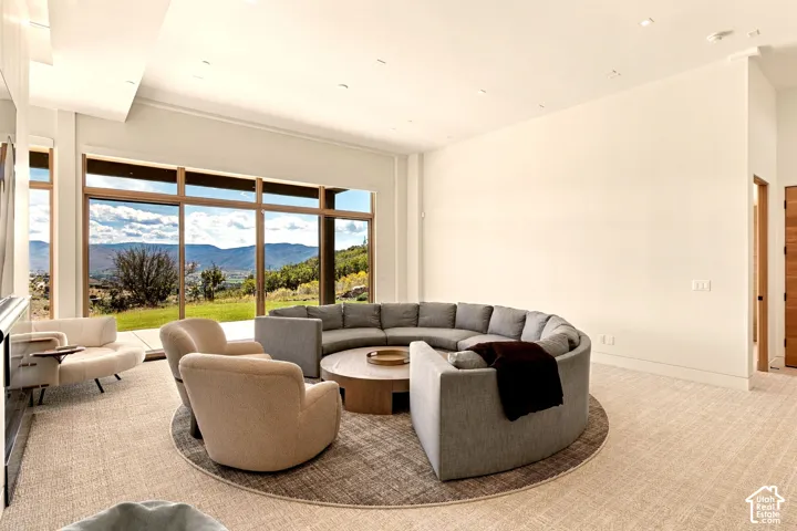 Expansive floor-to-ceiling windows, high ceilings, recessed lighting, and light-toned wall finishes