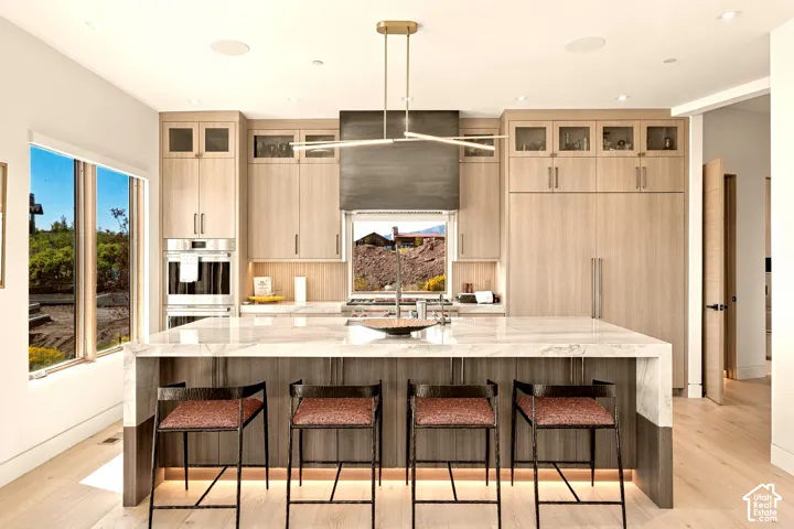 Contemporary kitchen featuring custom wood-finish cabinetry, a large center island with integrated seating, and high-end built-in appliances