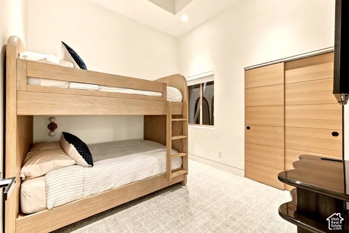 Recessed lighting, wood-finish sliding wardrobe doors, and a window with architectural details