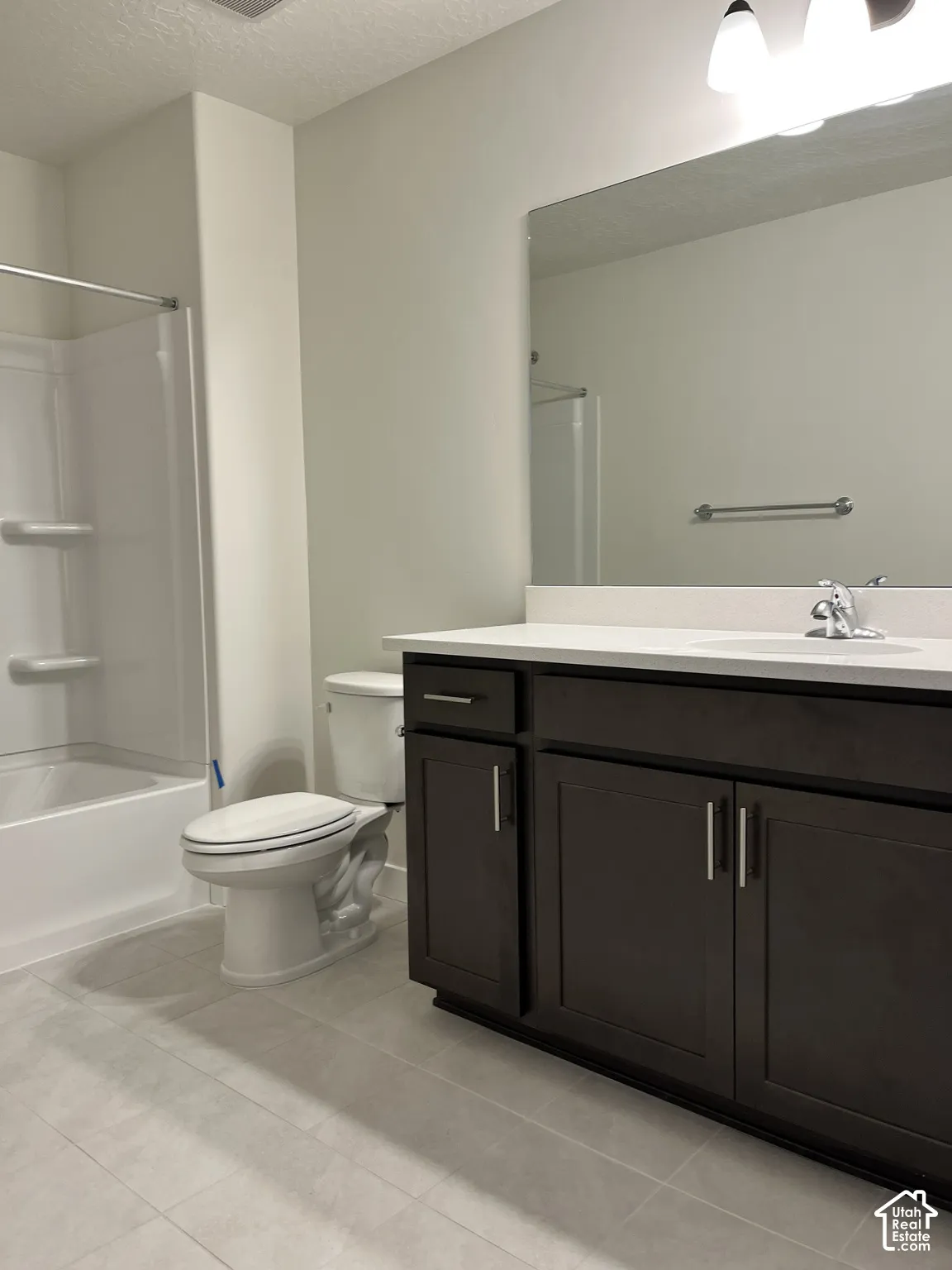 Dark-stained vanity with silver-tone hardware, white countertop, and integrated sink