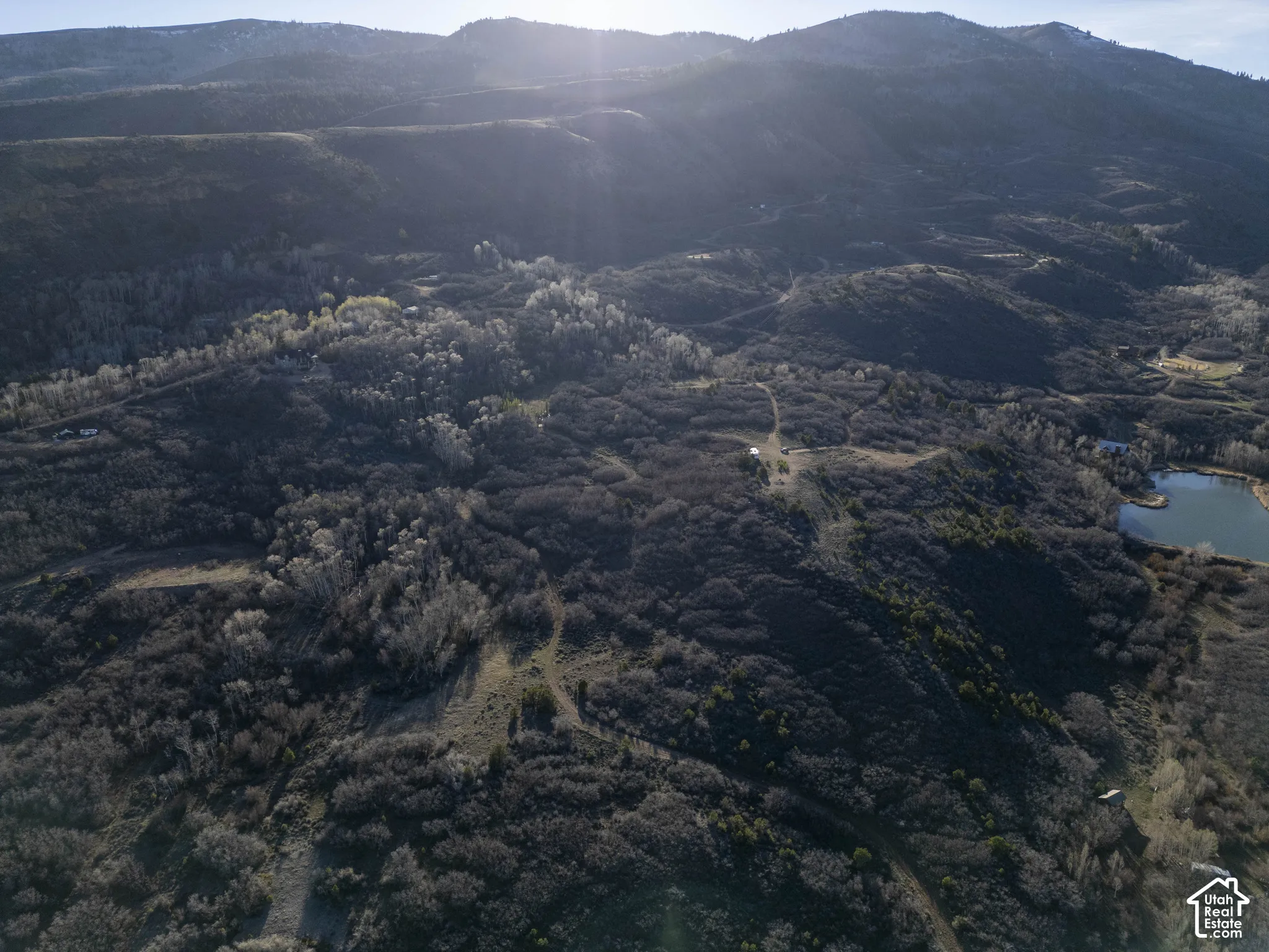 Expansive undeveloped land featuring natural terrain, distant mountains, and a body of water