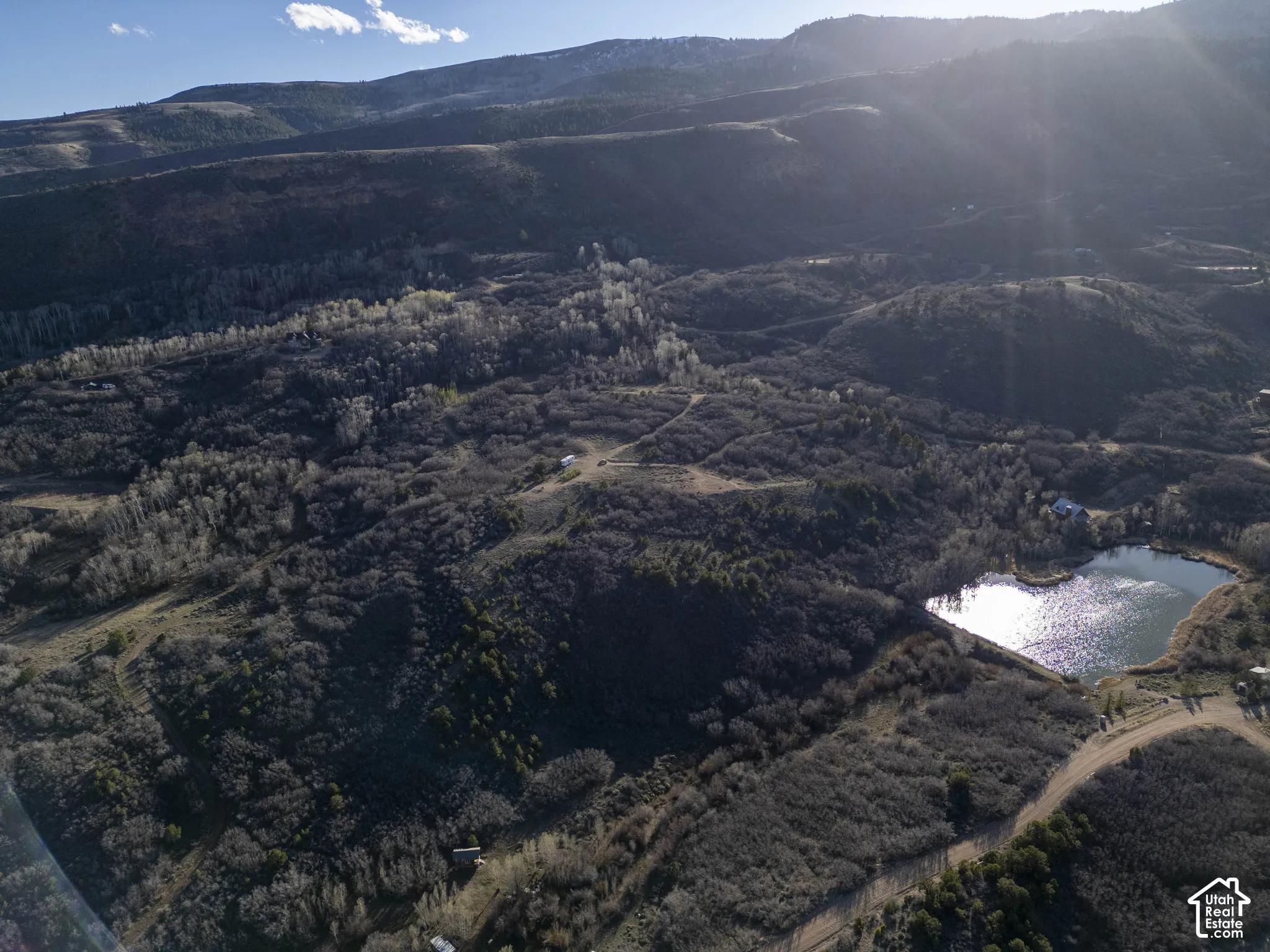Expansive property featuring a private pond, mountainous terrain, and scattered trees