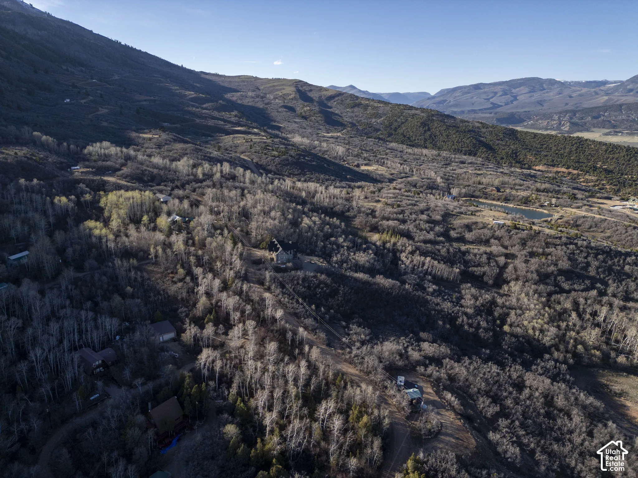 Expansive mountain terrain featuring diverse tree coverage and multiple structures