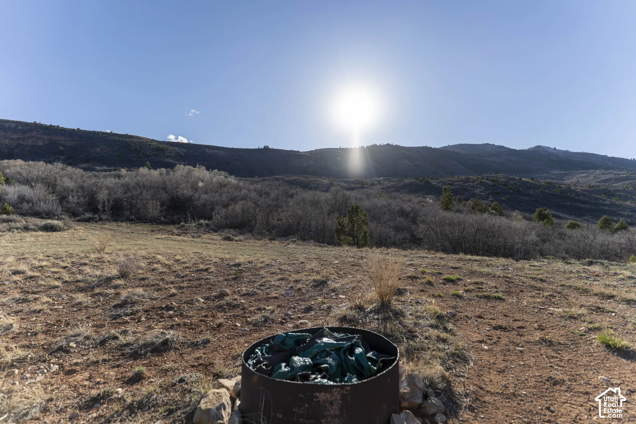 Expansive undeveloped land featuring natural terrain and distant mountain backdrop