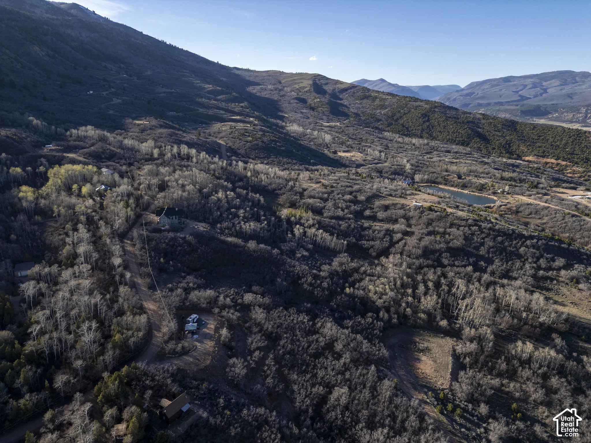 Mountainous terrain featuring expansive forested areas and a distinct body of water