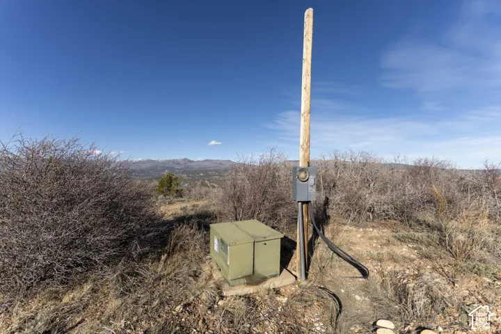 Site with utility pole, electrical meter, and service box, set against a distant mountain range